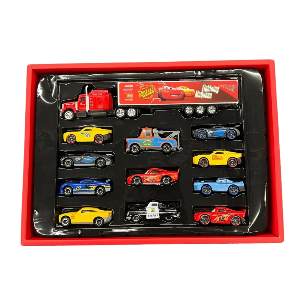Set me 12 automjete lodër McQueen, i përbërë nga një kamion dhe 11 makina të vogla metalike me ngjyra dhe dizajne të ndryshme, ideal për lojëra dhe argëtim