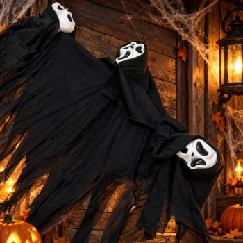 Pamje nga afër e fantazmës Halloween me tri maska të bardha, kapuçë të zinj dhe pëlhurë të gjatë me skaje të copëzuara.